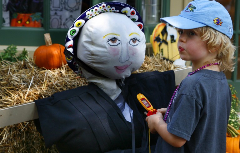 Little boy next to scarecrow